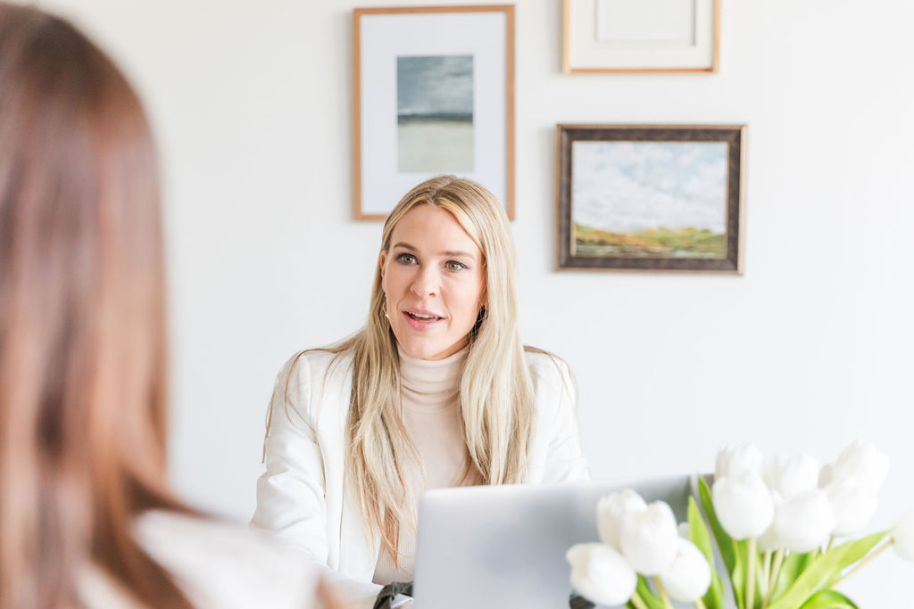 Chelsea Cadwell owner of Intoto Talent Recruiting talking to a client at her computer